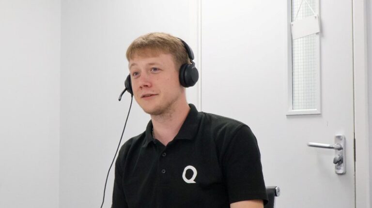A Qlic employee wearing a headset while providing telephony as a service