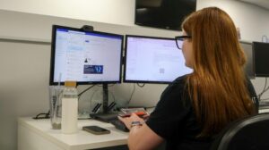 A Qlic employee working at a dual-monitor workstation to support nonprofits with TaaS